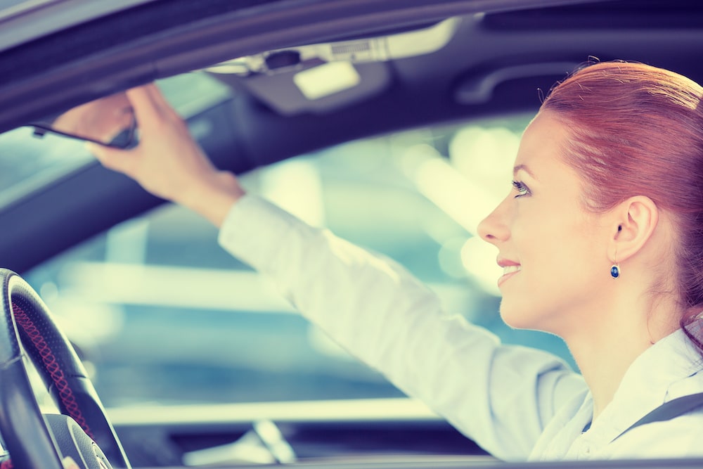 Driving Habits. Девушка смотрит на водителя. Водитель смотрит в зеркало.